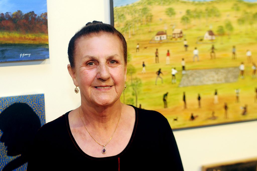 Marlene Gilson (Wadawurrung/Wathaurung), winner of the Lend Lease Reconciliation Award in front of her painting Cricket Match At Coranderrk 2014, acrylic on canvas.